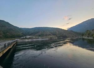 a bridge over a river with mountains in the background at Borbardha the 7 xhuxhat in Tropojë
