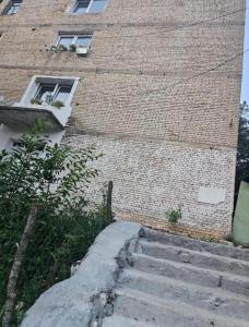 a brick building with stairs in front of it at Borbardha the 7 xhuxhat in Tropojë