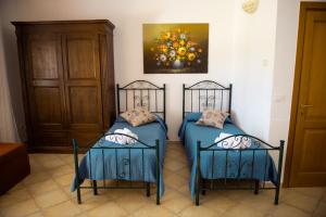 two beds in a room with a painting on the wall at Villa Conca Marco in Torre dell'Orso
