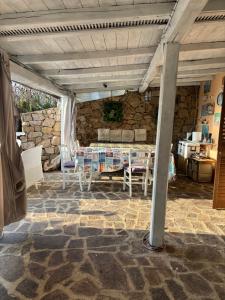 a living room with a table and a stone wall at Casa Azzurra in Porto San Paolo