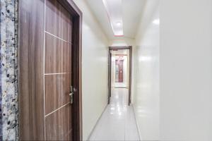 un pasillo vacío con una puerta de madera y un pasillo en FabHotel Rameshwar Inn, en Jhūsi