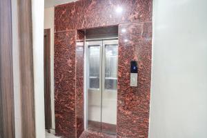 un ascensor de cristal en una habitación con una pared roja en FabHotel Rameshwar Inn, en Jhūsi