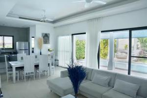 a living room with a white couch and a table at Villa Cannes with gym and tennis court in Choeng Mon Beach