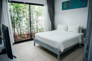 a white bed in a room with a large window at Villa Cannes with gym and tennis court in Choeng Mon Beach +44 photos