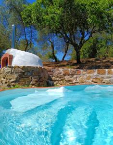 a swimming pool with a stone wall and an igloo at Country home in the Chiantishire close to Florence in L'Ugolino
