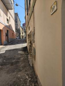 an alley with a sign on the side of a building at La Stanza di Chiara - Maison à Porter in Vasto