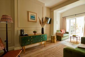a living room with a green dresser and a couch at Georgian House Hotel in London