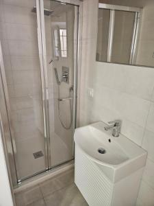a white bathroom with a shower and a sink at La Stanza di Chiara - Maison à Porter in Vasto