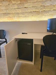 a white desk with two chairs and a monitor on it at La Stanza di Chiara - Maison à Porter in Vasto +14 photos