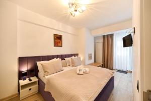 a bedroom with a bed with two candles on it at Nikola Apartment Infinity Resort in Mamaia +26 photos