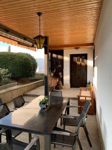 a patio with a wooden ceiling and a table and chairs at Chalet Wienerwald in Königstetten +23 photos