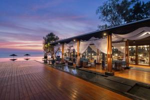 a resort with a deck with tables and chairs at V Villas Hua Hin - MGallery Collection in Hua Hin