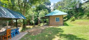 a small building with a blue roof in a yard at Ploy&Praew House 1 in Ban Sop Mae Klang