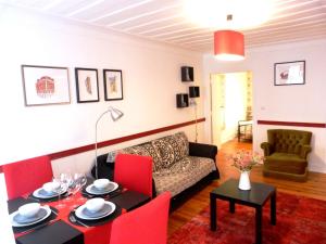 - un salon avec un canapé et une table avec des chaises rouges dans l'établissement Atalaia 68, à Lisbonne