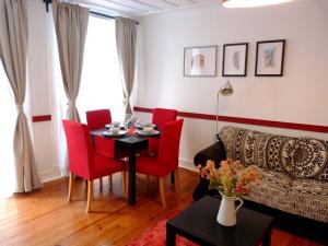 - un salon avec une table et des chaises rouges dans l'établissement Atalaia 68, à Lisbonne
