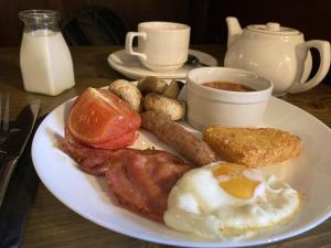 a plate of breakfast food with eggs bacon and sausage at Red Lion in Winfrith Newburgh