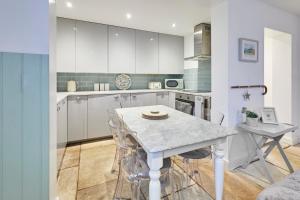 a kitchen with white cabinets and a table with chairs at Host & Stay - The Courtyard Retreat in Whitby