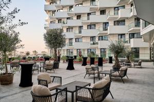 a patio with tables and chairs in front of a building at Nikola Apartment Infinity Resort in Mamaia