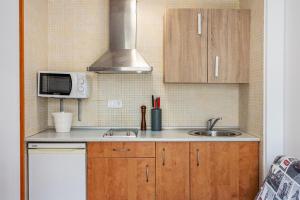 eine kleine Küche mit Spüle und Mikrowelle in der Unterkunft Monte Gorbea Mumu 7 B in Sierra Nevada