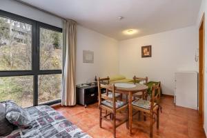 Una sala de estar con una mesa y sillas y una ventana. en Monte Gorbea Mumu 7 B, en Sierra Nevada