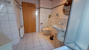a small bathroom with a toilet and a sink at Residenz am Deich NDD 28 in Norden +17 photos