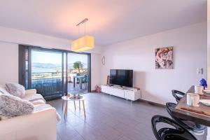 Una sala de estar con un sofá y un televisor. en Clos Vignola - Domaine de la Viva -Superbe vue mer, en Grosseto-Prugna