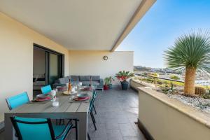 Una mesa y sillas en el balcón de una casa. en Clos Vignola - Domaine de la Viva -Superbe vue mer, en Grosseto-Prugna