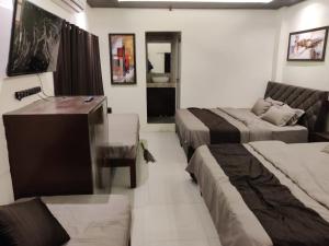 a hotel room with two beds and a couch at rudra homestay in Ujjain
