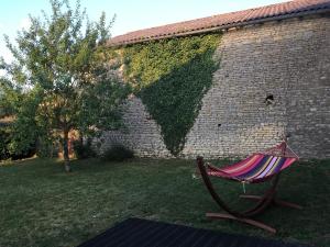 a hammock in a yard next to a brick wall at Le Nid de Cissé in Cissé