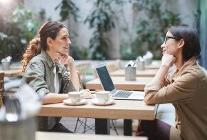 two women sitting at a table with a laptop at Studio 6 Anaheim Hills CA in Anaheim