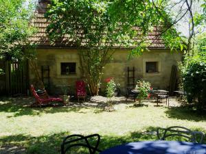 a garden with chairs and tables in front of a house at Wohnung im Kutscherhaus in Wetzhausen