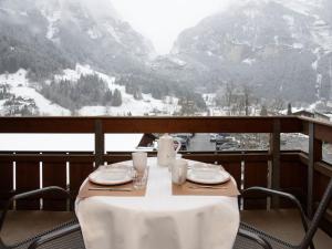 a table on a balcony with a view of a snow covered mountain at Apartment Chalet Abendrot apARTments-10 by Interhome in Grindelwald