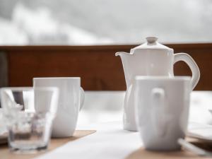 a white tea pot and cups on a table at Apartment Chalet Abendrot apARTments-10 by Interhome in Grindelwald