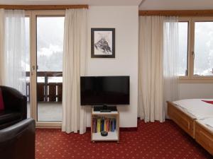 a hotel room with a television and a bed at Apartment Chalet Abendrot apARTments-10 by Interhome in Grindelwald +26 photos