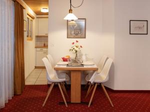 a dining room with a table and white chairs at Apartment Chalet Abendrot apARTments-13 by Interhome in Grindelwald