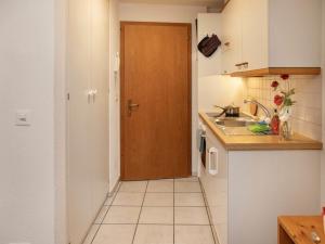 a kitchen with a wooden door and a sink at Apartment Chalet Abendrot apARTments-3 by Interhome in Grindelwald
