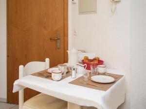 uma mesa branca com pratos e chávenas e uma taça de fruta em Apartment Chalet Abendrot apARTments-6 by Interhome em Grindelwald