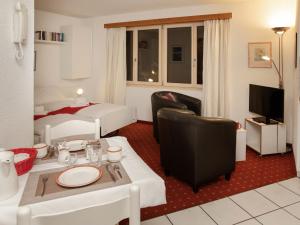 uma sala de estar com uma cama e um quarto com uma mesa e cadeiras em Apartment Chalet Abendrot apARTments-6 by Interhome em Grindelwald