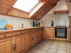 a kitchen with wooden cabinets and a skylight at Holiday Home Milin-Avel by Interhome in Telgruc-sur-Mer