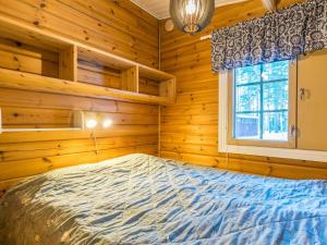 um quarto com uma cama num chalé de madeira em Holiday Home Aittoniemi i by Interhome em Hopsu