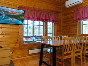 uma sala de jantar com mesa e cadeiras e uma TV em Holiday Home Aittolahti 2 by Interhome em Hopsu