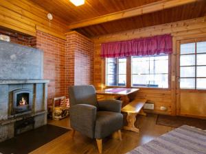 uma sala de estar com uma cadeira e uma lareira em Holiday Home Aittoniemi ii by Interhome em Hopsu
