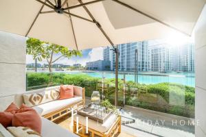 a living room with a view of a pool at LUX The District One Lagoon View Suite in Dubai