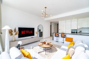 a living room with a couch and a table at LUX The District One Lagoon View Suite in Dubai