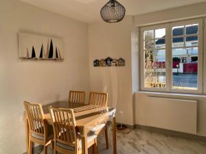 a dining room with a table and chairs and a window at Appartement à Cancale situé à 500 m du port in Cancale +4 photos