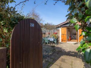une porte en bois dans un jardin avec une maison en arrière-plan dans l'établissement Holiday Home Paradise Océan-16 by Interhome, à Capbreton