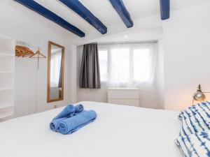 a bedroom with a white bed with blue towels on it at Apartment Mestral Atic by Interhome in Tossa de Mar