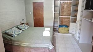 a bedroom with a bed and a book shelf at Departamentos El Bolson in El Bolsón