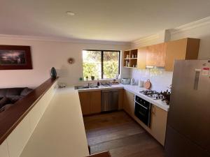 a small kitchen with a sink and a refrigerator at Alella by the sea in Gnarabup