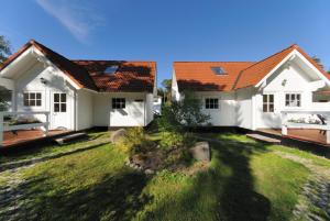 two white houses with red roofs in a yard at Gaststätte und Pension Zum Klausner in Kloster